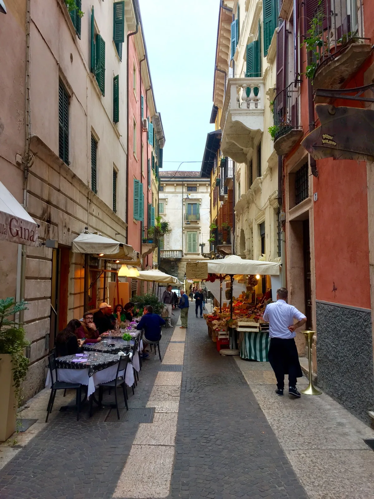 Outdoor restaurant seating in a narrow Italian street