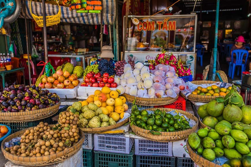 Vietnamese fresh fruit stall selling mango and pineapple, lower-risk street food option for allergy travelers