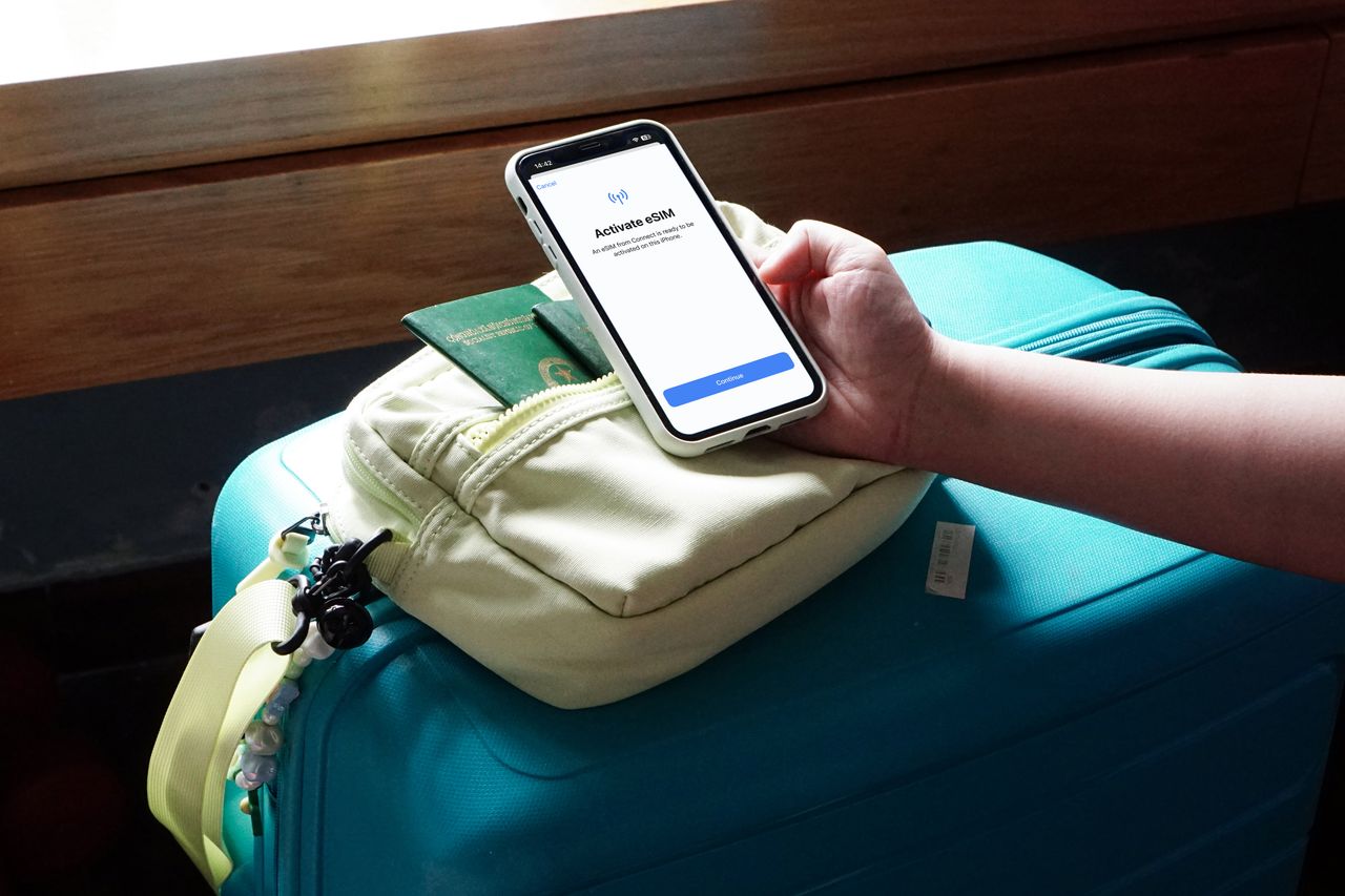 Traveler checking eSIM signal on a phone on an Asia street: staying connected guide